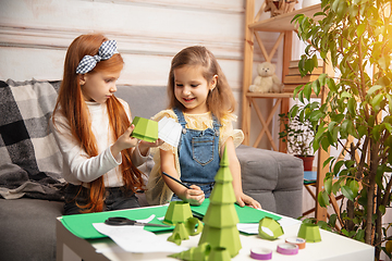 Image showing Two little children, girls together in creativity of the house. Happy kids make handmade toys for games or New Year celebration