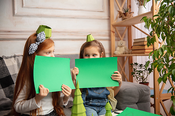 Image showing Two little children, girls together in creativity of the house. Happy kids make handmade toys for games or New Year celebration