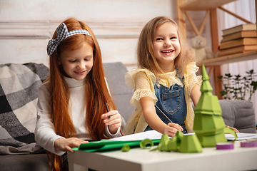 Image showing Two little children, girls together in creativity of the house. Happy kids make handmade toys for games or New Year celebration