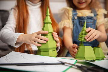 Image showing Close up hands of two little children, girls together in creativity of the house. Kids make handmade toys for games or New Year celebration