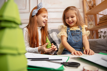 Image showing Two little children, girls together in creativity of the house. Happy kids make handmade toys for games or New Year celebration