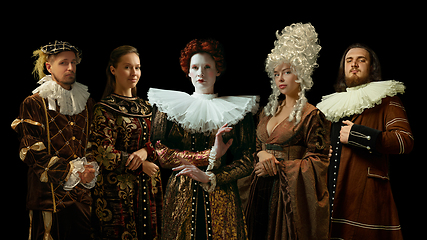 Image showing Medieval people as a royalty persons in vintage clothing on dark background. Concept of comparison of eras, modernity and renaissance. Creative collage.