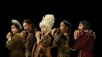 Image showing Medieval people as a royalty persons in vintage clothing on dark background. Concept of comparison of eras, modernity and renaissance. Creative collage.