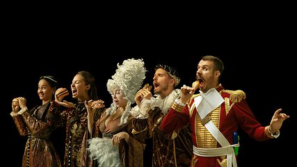 Image showing Medieval people as a royalty persons in vintage clothing on dark background. Concept of comparison of eras, modernity and renaissance. Creative collage.