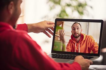 Image showing Celebration and holidays during quarantine concept. Friends or family unpacking gifts while talking using video call