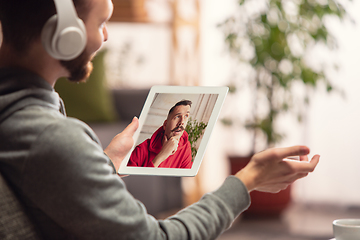 Image showing Celebration and holidays during quarantine concept. Friends or family unpacking gifts while talking using video call