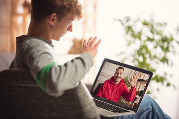 Image showing Celebration and holidays during quarantine concept. Friends or family unpacking gifts while talking using video call