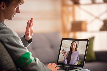 Image showing Celebration and holidays during quarantine concept. Friends or family unpacking gifts while talking using video call