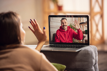 Image showing Celebration and holidays during quarantine concept. Friends or family unpacking gifts while talking using video call