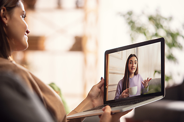 Image showing Celebration and holidays during quarantine concept. Friends or family unpacking gifts while talking using video call