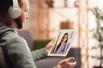 Image showing Celebration and holidays during quarantine concept. Friends or family unpacking gifts while talking using video call