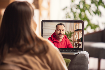 Image showing Celebration and holidays during quarantine concept. Friends or family unpacking gifts while talking using video call