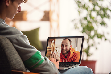 Image showing Celebration and holidays during quarantine concept. Friends or family unpacking gifts while talking using video call