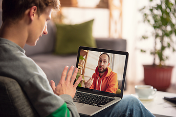 Image showing Celebration and holidays during quarantine concept. Friends or family unpacking gifts while talking using video call