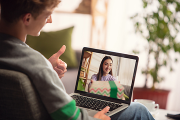 Image showing Celebration and holidays during quarantine concept. Friends or family unpacking gifts while talking using video call