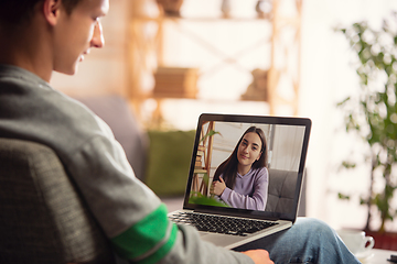 Image showing Celebration and holidays during quarantine concept. Friends or family unpacking gifts while talking using video call