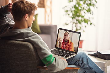 Image showing Celebration and holidays during quarantine concept. Friends or family unpacking gifts while talking using video call