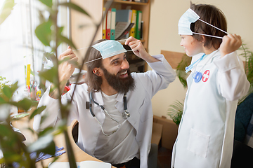 Image showing Paediatrician doctor examining a child in comfortabe medical office