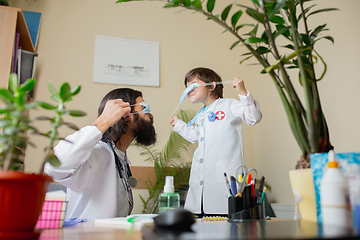 Image showing Paediatrician doctor examining a child in comfortabe medical office