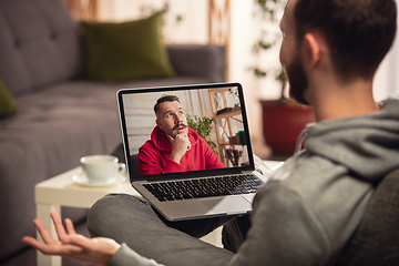 Image showing Celebration and holidays during quarantine concept. Friends or family unpacking gifts while talking using video call