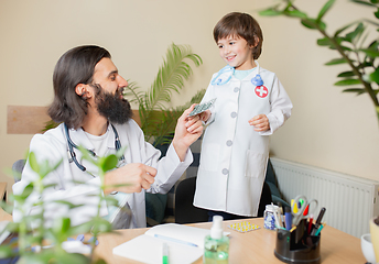 Image showing Paediatrician doctor examining a child in comfortabe medical office