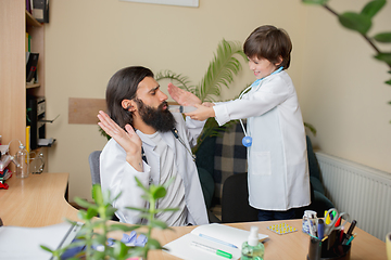 Image showing Paediatrician doctor examining a child in comfortabe medical office