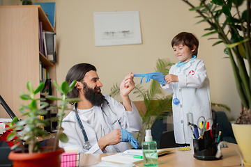 Image showing Paediatrician doctor examining a child in comfortabe medical office