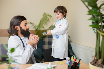 Image showing Paediatrician doctor examining a child in comfortabe medical office