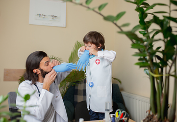 Image showing Paediatrician doctor examining a child in comfortabe medical office