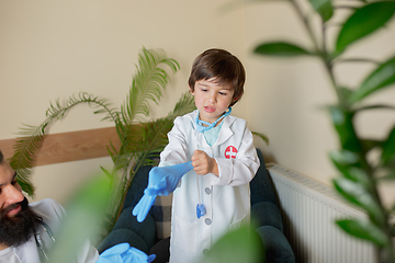 Image showing Paediatrician doctor examining a child in comfortabe medical office