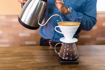 Image showing Barista pouring water on coffe