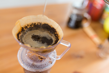 Image showing Pouring hot water into coffee drip filter 