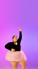 Image showing Beautiful caucasian plus size model practicing ballet dance on gradient purple-pink studio background in neon light