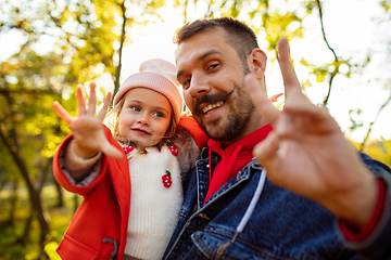 Image showing Happy father and little cute daughter walking down the forest path in autumn sunny day