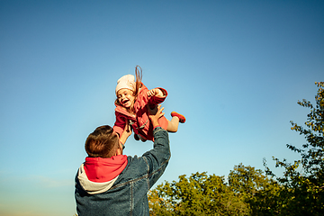 Image showing Happy father and little cute daughter walking down the forest path in autumn sunny day