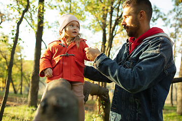 Image showing Happy father and little cute daughter walking down the forest path in autumn sunny day