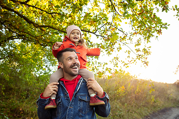 Image showing Happy father and little cute daughter walking down the forest path in autumn sunny day