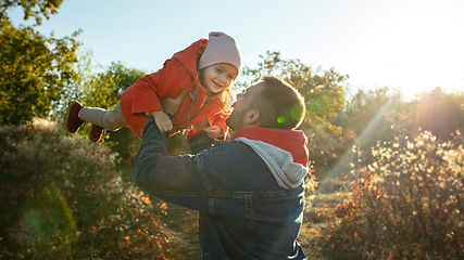 Image showing Happy father and little cute daughter walking down the forest path in autumn sunny day