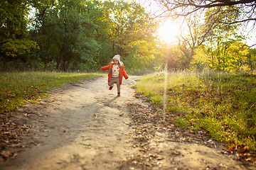 Image showing Happy father and little cute daughter walking down the forest path in autumn sunny day