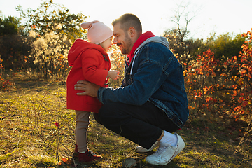 Image showing Happy father and little cute daughter walking down the forest path in autumn sunny day