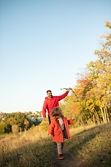 Image showing Happy father and little cute daughter walking down the forest path in autumn sunny day