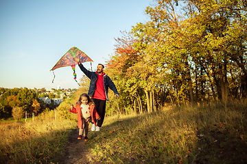 Image showing Happy father and little cute daughter walking down the forest path in autumn sunny day