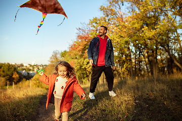 Image showing Happy father and little cute daughter walking down the forest path in autumn sunny day