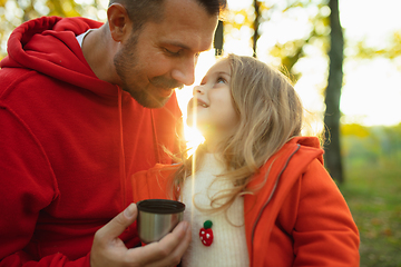 Image showing Happy father and little cute daughter walking down the forest path in autumn sunny day