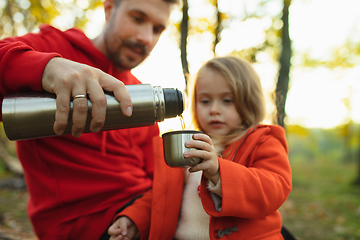 Image showing Happy father and little cute daughter walking down the forest path in autumn sunny day