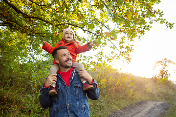 Image showing Happy father and little cute daughter walking down the forest path in autumn sunny day