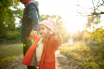 Image showing Happy father and little cute daughter walking down the forest path in autumn sunny day