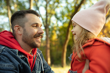 Image showing Happy father and little cute daughter walking down the forest path in autumn sunny day