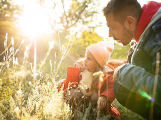 Image showing Happy father and little cute daughter walking down the forest path in autumn sunny day