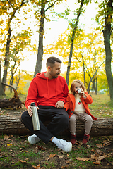 Image showing Happy father and little cute daughter walking down the forest path in autumn sunny day